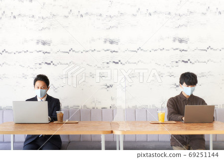 A man in a mask sitting at a distance 69251144