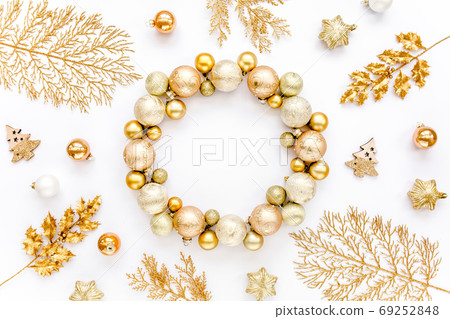 Holiday round frame, pattern made and gold glass Christmas balls, golden leaves isolated on a white background. Merry Christmas. Flat lay, top view Holiday round frame, pattern made and gold glass Christmas balls, golden leaves isolated on a white background. Merry Christmas. Flat lay, top view 69252848