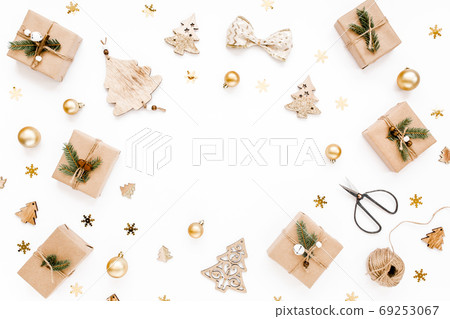 Christmas frame, pattern made in gold colors and craft boxes on white background. Holiday and celebration concept. Top view. Flat lay 69253067