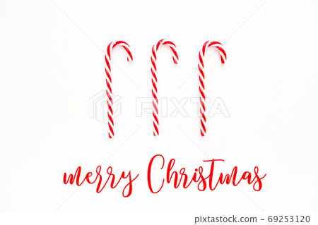 Merry Christmas card with Candy cane. Candies on white background. Flat lay, top view. Merry Christmas card with Candy cane. Candies on white background. Flat lay, top view. 69253120