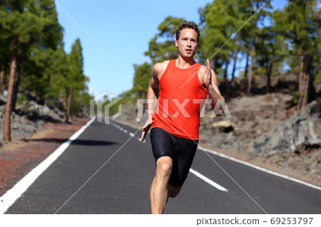 Running sprinting athlete man on road training 69253797