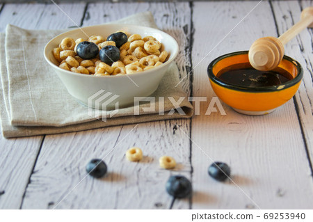 Honey rings with blueberries in a bowl on wooden background. Breakfast 69253940