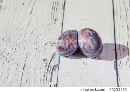 Trendy ugly organic fruit purple plum on the wooden background. Trendy ugly organic fruit purple plum on the wooden background. 69253963