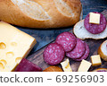 exquisite rustic table with various cheeses, salami and fresh bread 69256903