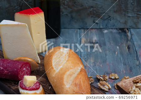 exquisite rustic table with various cheeses, salami and fresh bread 69256971