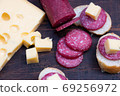 exquisite rustic table with various cheeses, salami and fresh bread 69256972