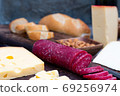 exquisite rustic table with various cheeses, salami and fresh bread 69256974