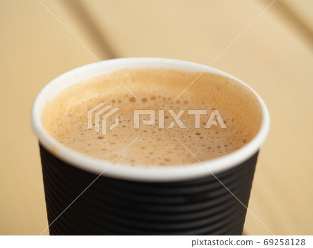 Full paper glass of coffee. Foam texture. Close-up 69258128