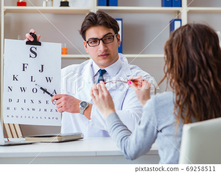 The doctor optician with letter chart conducting an eye test che 69258511
