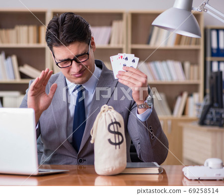 The businessman gambling playing cards at work The businessman gambling playing cards at work 69258514