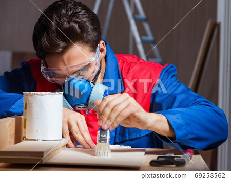Young man gluing wood pieces together in DIY concept 69258562