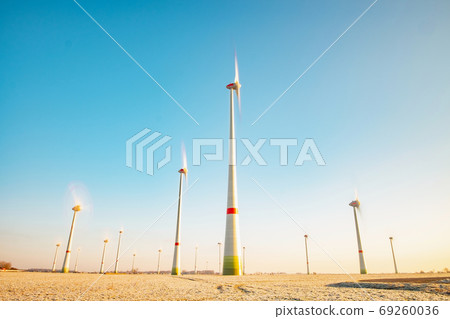 Harvested wheat field with turning windmill turbines Harvested wheat field with turning windmill turbines 69260036