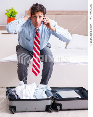 Young handsome businessman preparing for trip 69260080
