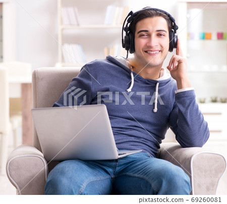 Young handsome man listening to music with headphones 69260081