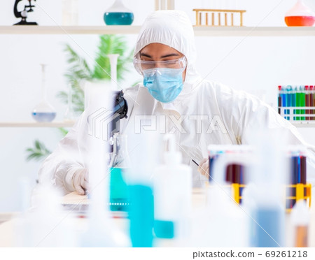 Young chemist student working in lab on chemicals 69261218