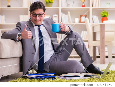 Businessman working on the floor at home Businessman working on the floor at home 69261769