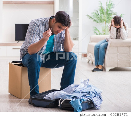 Woman evicting man from house during family conflict Woman evicting man from house during family conflict 69261771