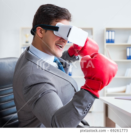 Man boxing in the office with virtual reality goggles Man boxing in the office with virtual reality goggles 69261773