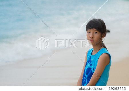 A lonely Asian girl with the sun and the beach by the sea on a clear day. 69262533