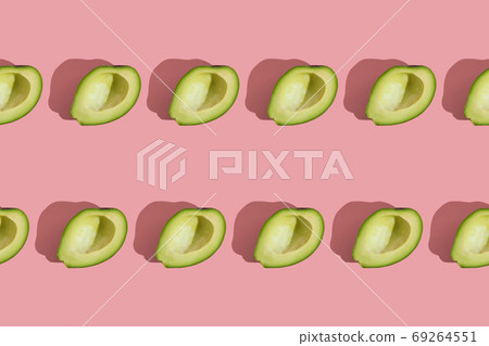 Trending style pattern of half seedless green avocado on pink background with hard light. Creative food texture. 69264551