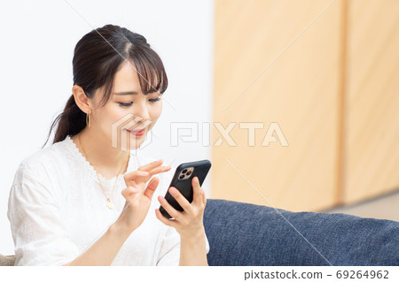 A woman using a smartphone A woman using a smartphone 69264962