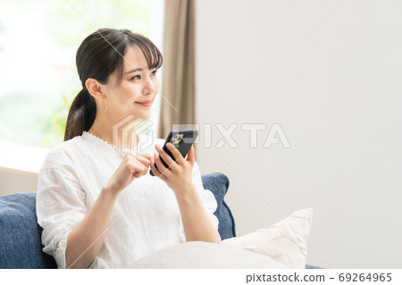 A woman using a smartphone A woman using a smartphone 69264965