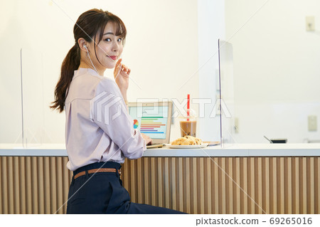 一個女人在一家咖啡館與壓克力隔斷 69265016