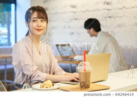A woman working at a cafe with an acrylic partition A woman working at a cafe with an acrylic partition 69266414