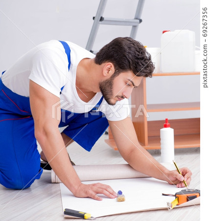 Repairman doing renovation repair in the house with paper wallpa Repairman doing renovation repair in the house with paper wallpa 69267356