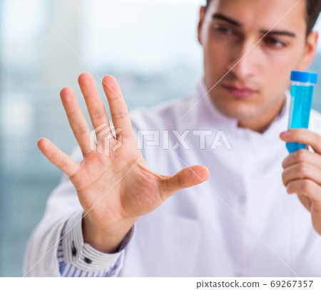 Young chemist pressing virtual buttons in lab Young chemist pressing virtual buttons in lab 69267357