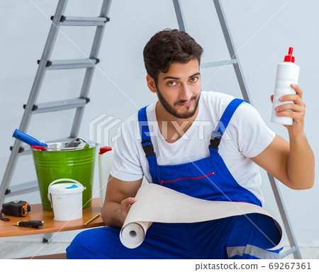 Repairman doing renovation repair in the house with paper wallpa Repairman doing renovation repair in the house with paper wallpa 69267361