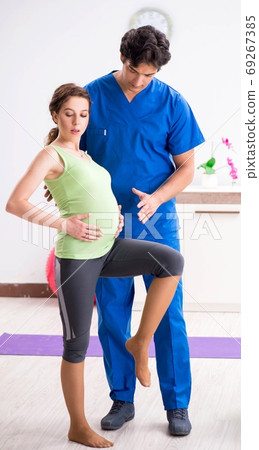 Pregnant woman doing physical exercies with instructor Pregnant woman doing physical exercies with instructor 69267385