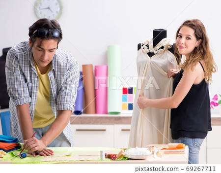 Young tailor working in his workshop Young tailor working in his workshop 69267711