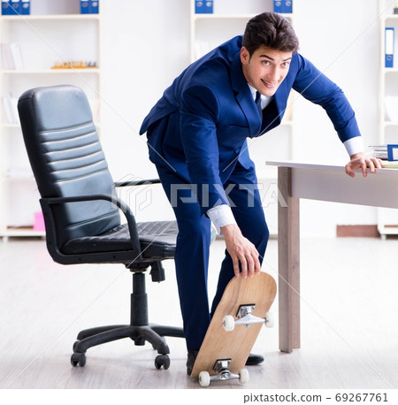 Young businessman with skate in office in sports concept Young businessman with skate in office in sports concept 69267761
