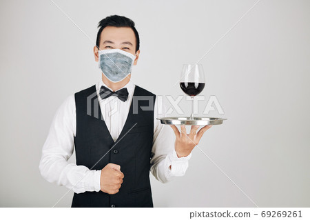 Restaurant waiter serving wine Restaurant waiter serving wine 69269261