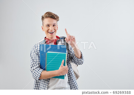 Student with books pointing in the air Student with books pointing in the air 69269388