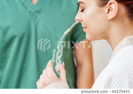 Woman receives nasal inhalation. 69270445