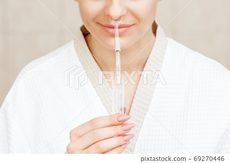Woman receives nasal inhalation. Woman receives nasal inhalation. 69270446