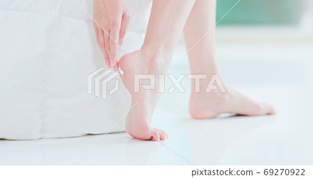 Woman applying cream onto heel Woman applying cream onto heel 69270922
