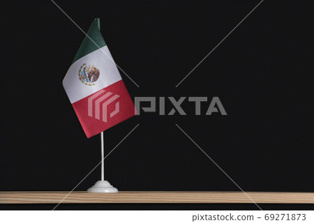 Flag pole. National flag of Mexico on table. Black background. Copy space 69271873