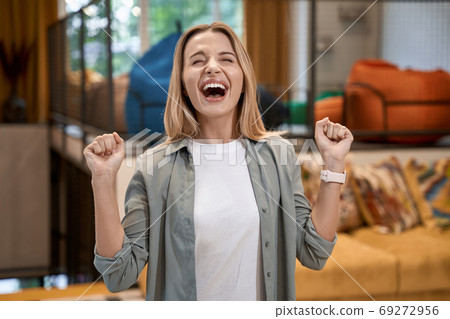 Good news at work, portrait of a young excited caucasian woman celebrating success and feeling happy while standing in the modern office Good news at work, portrait of a young excited caucasian woman celebrating success and feeling happy while standing in the modern office 69272956