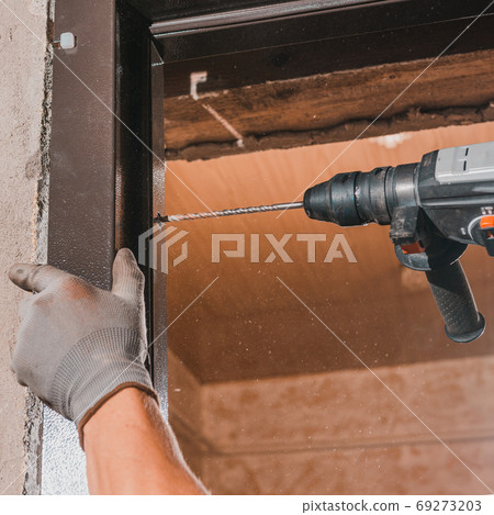 The master mounts a metal door frame, drills holes in the box and the wall for mounting. The master mounts a metal door frame, drills holes in the box and the wall for mounting. 69273203