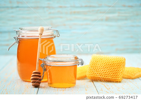 sweet honey on blue rustic table, with honeycomb. sweet honey on blue rustic table, with honeycomb. 69273417