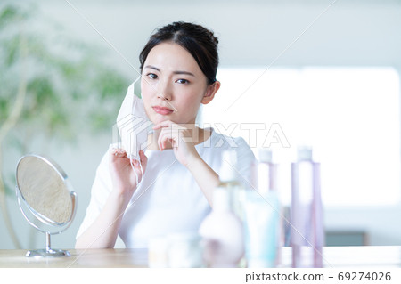 年輕女子擔心由於面膜粗糙的皮膚 年輕女子擔心由於面膜粗糙的皮膚 69274026