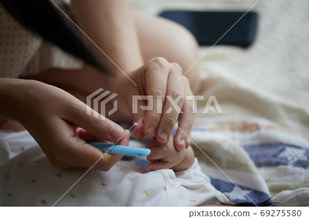 Two month old baby hands and baby nail clippers 69275580