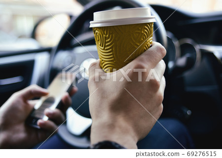 Male hold coffee and drive the car Male hold coffee and drive the car 69276515