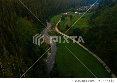 Carpathian river Bila Tisa, the largest tributary of the Danube, Ukrainian mountain river, top view of the river and the road In the village of Luhy. Carpathian river Bila Tisa, the largest tributary of the Danube, Ukrainian mountain river, top view of the river and the road In the village of Luhy. 69277318
