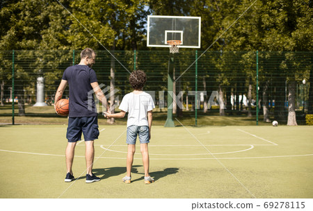 Man posing with son on basketball pitch back view Man posing with son on basketball pitch back view 69278115