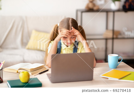Tired school girl having headache using pc Tired school girl having headache using pc 69278418