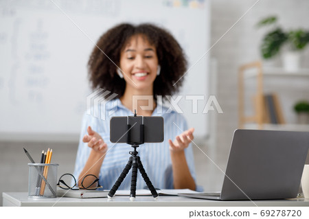 Educational training in class and lecture online. Tutor look at webcam in interior of living room Educational training in class and lecture online. Tutor look at webcam in interior of living room 69278720